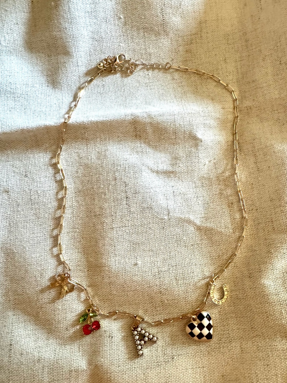 Gold Charm Necklace with Red Cherry and Black-White Heart.  Letter “A” charm.